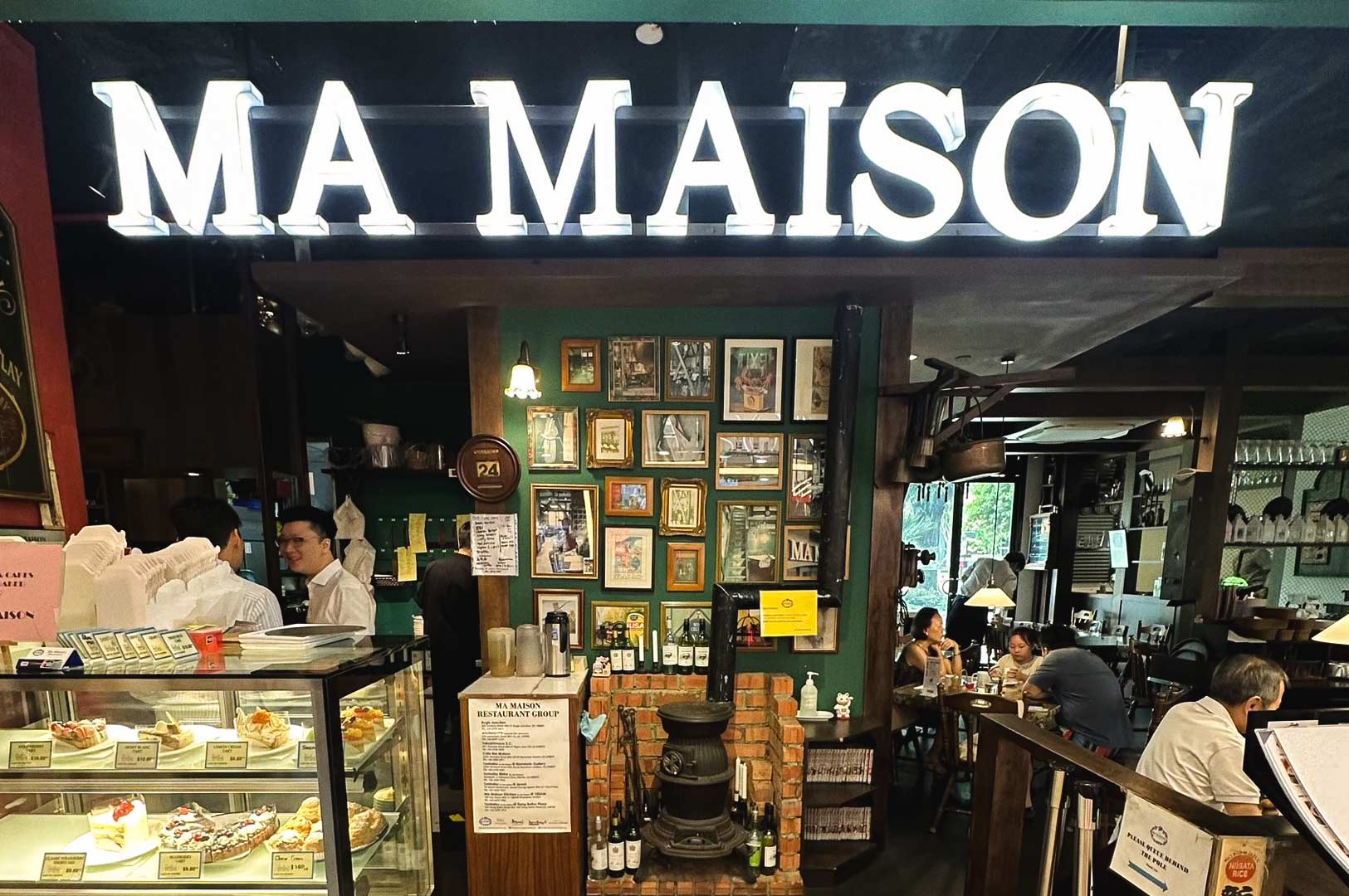Ma Maison restaurant entrance showcasing its vintage décor and pastry display.