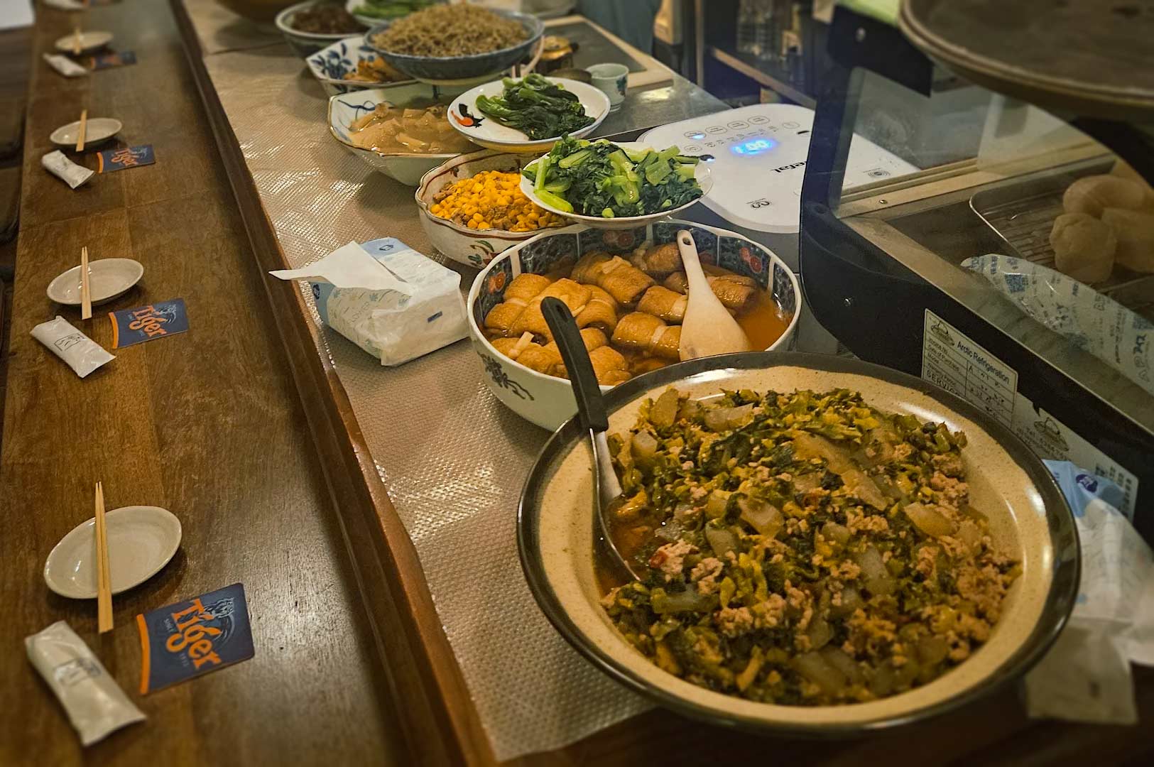 Japanese izakaya at Cuppage Plaza offering diverse food selection including vegetables, tofu, meat dishes, and traditional accompaniments.