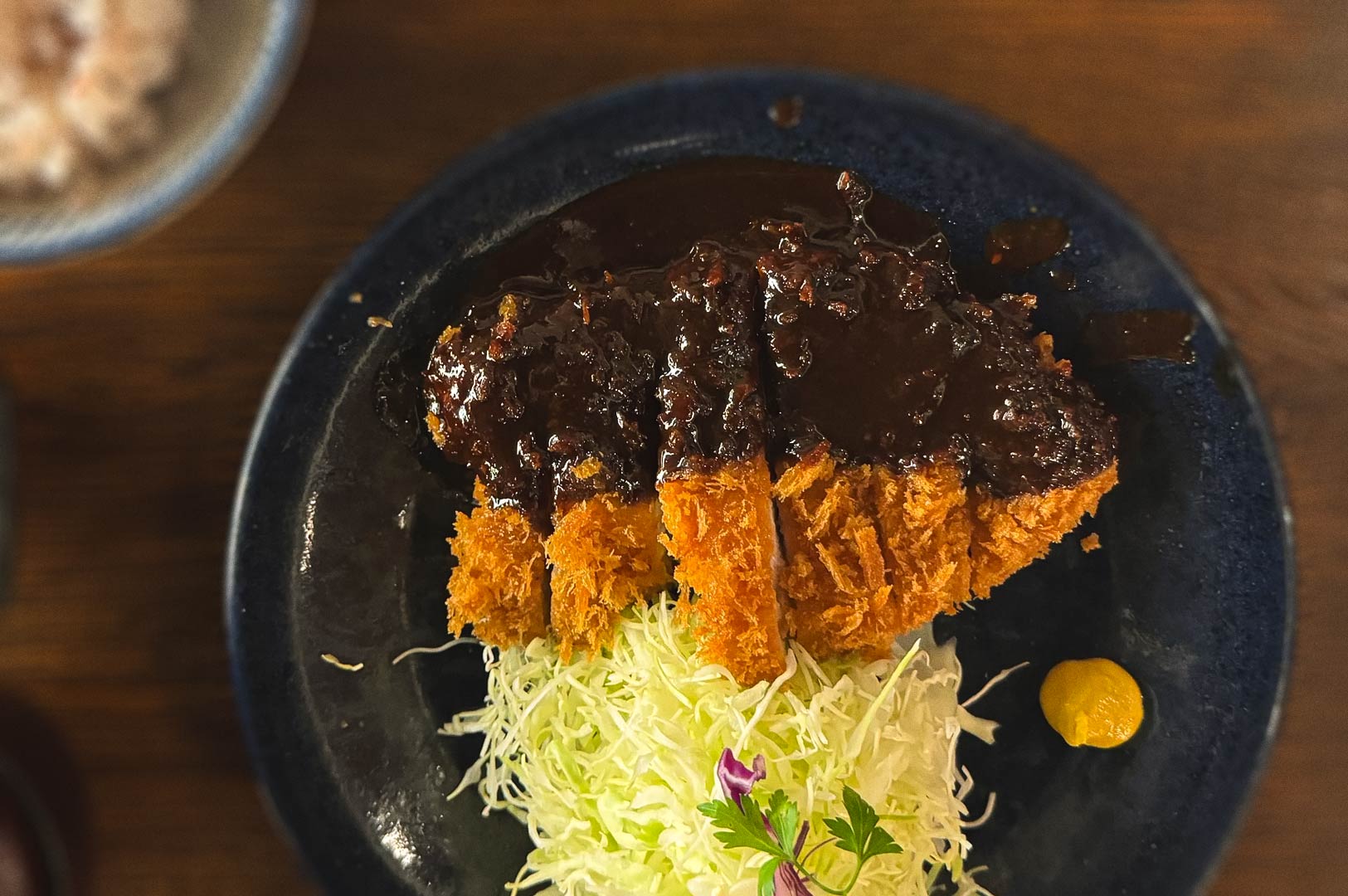 Crispy tonkatsu served with shredded cabbage and thick Japanese brown sauce.
