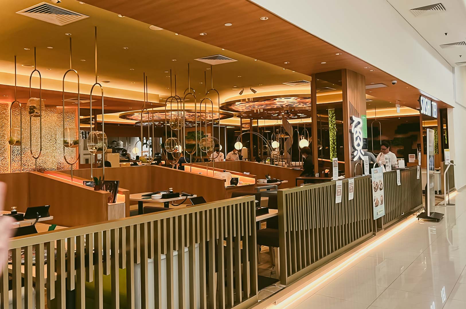 Sushi Tei Thomson Plaza restaurant entrance with modern Japanese interior, warm lighting, and wooden furnishings.