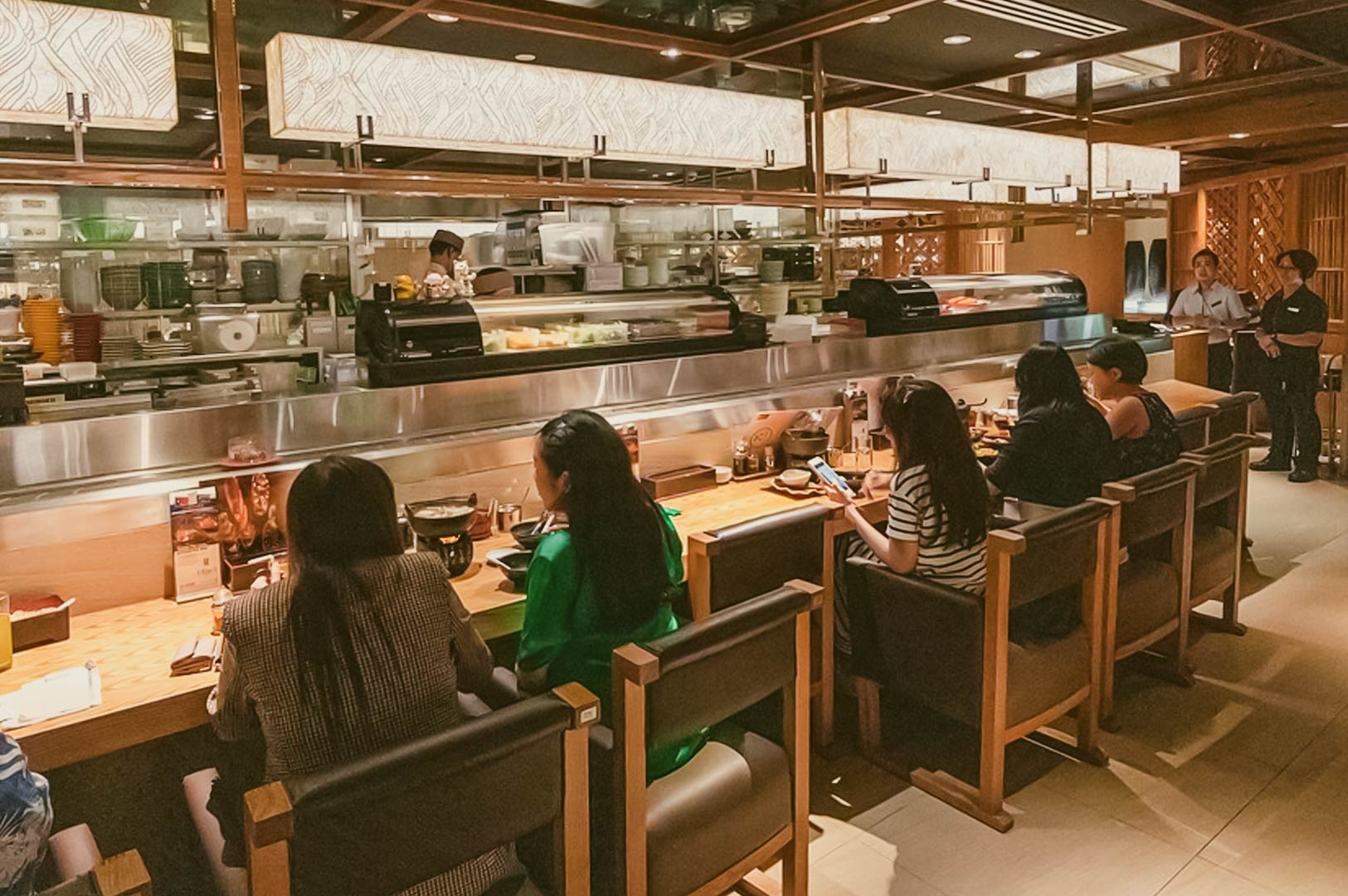 Elegant Japanese dining interior featuring booth seating, decorative glass elements, and upscale ambiance.