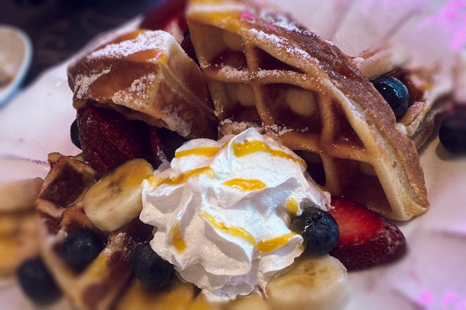 Belgian waffles with fruit and whipped cream.