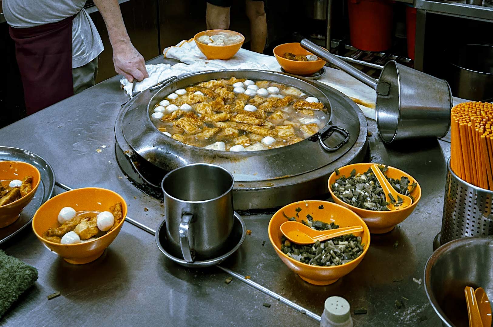 Large simmering pot of yong tau foo ingredients at a hawker stall.