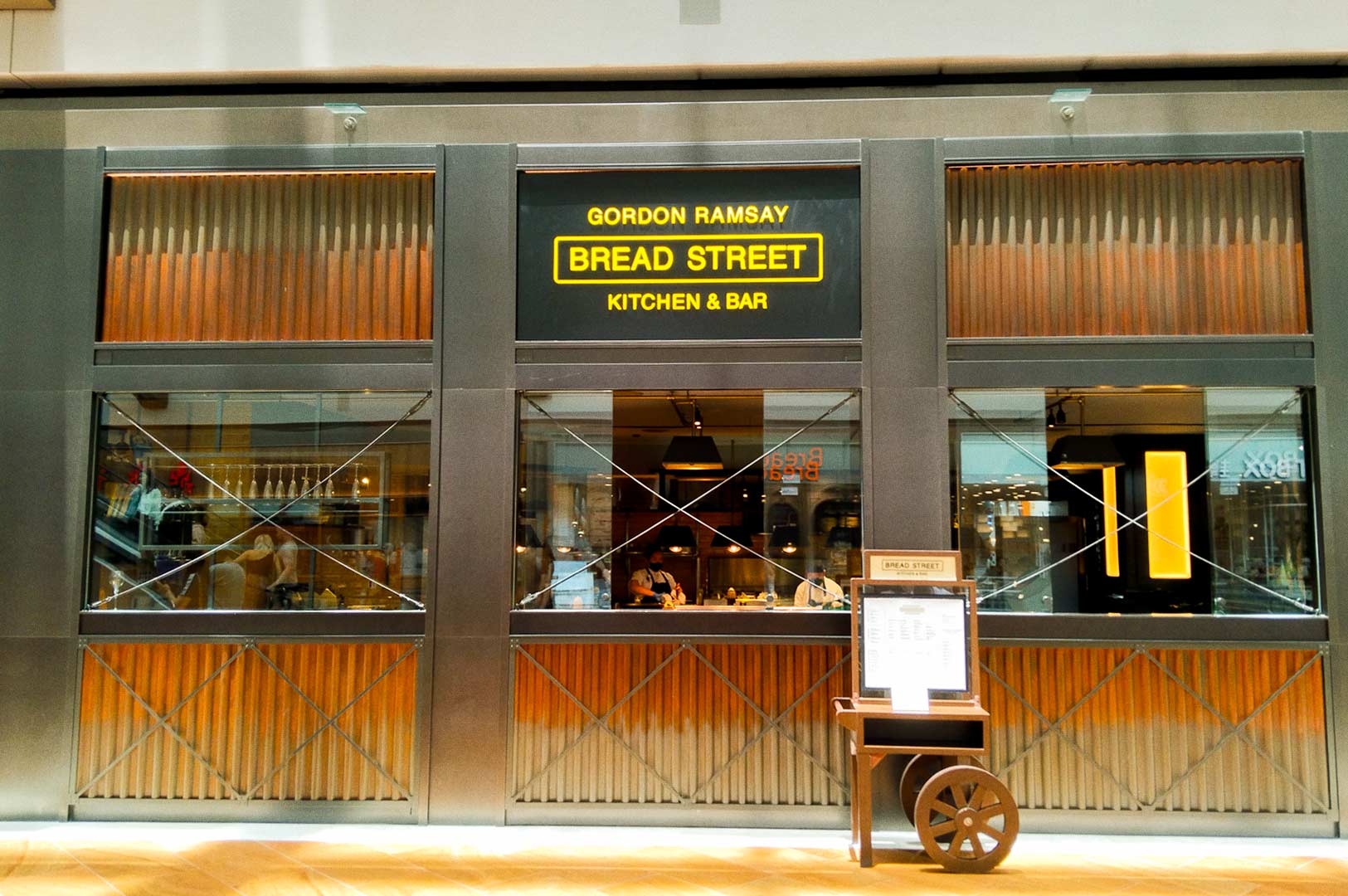 Exterior of a modern kitchen and bar with bold signage.