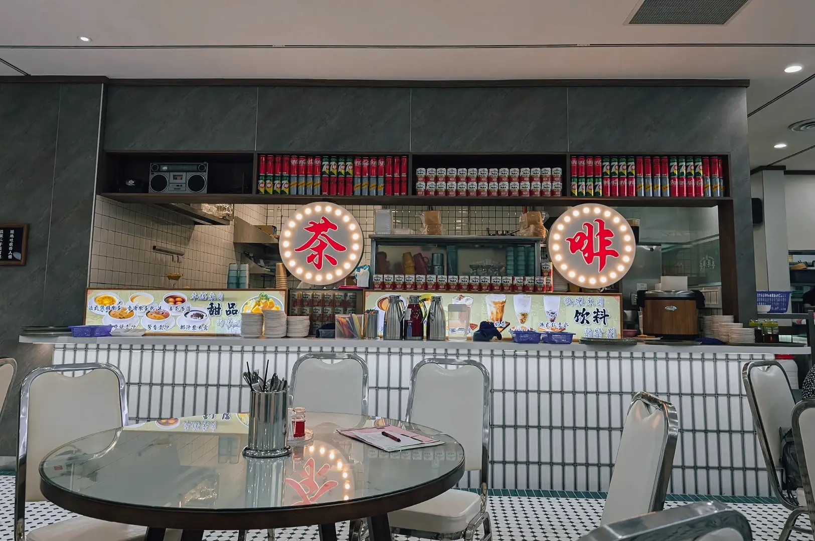 Wide-angle, eye-level shot of the interior service counter and dining area at a Hong Kong–style café restaurant, featuring Chinese character signage, tiled walls, classic diner seating, and a drink preparation station.