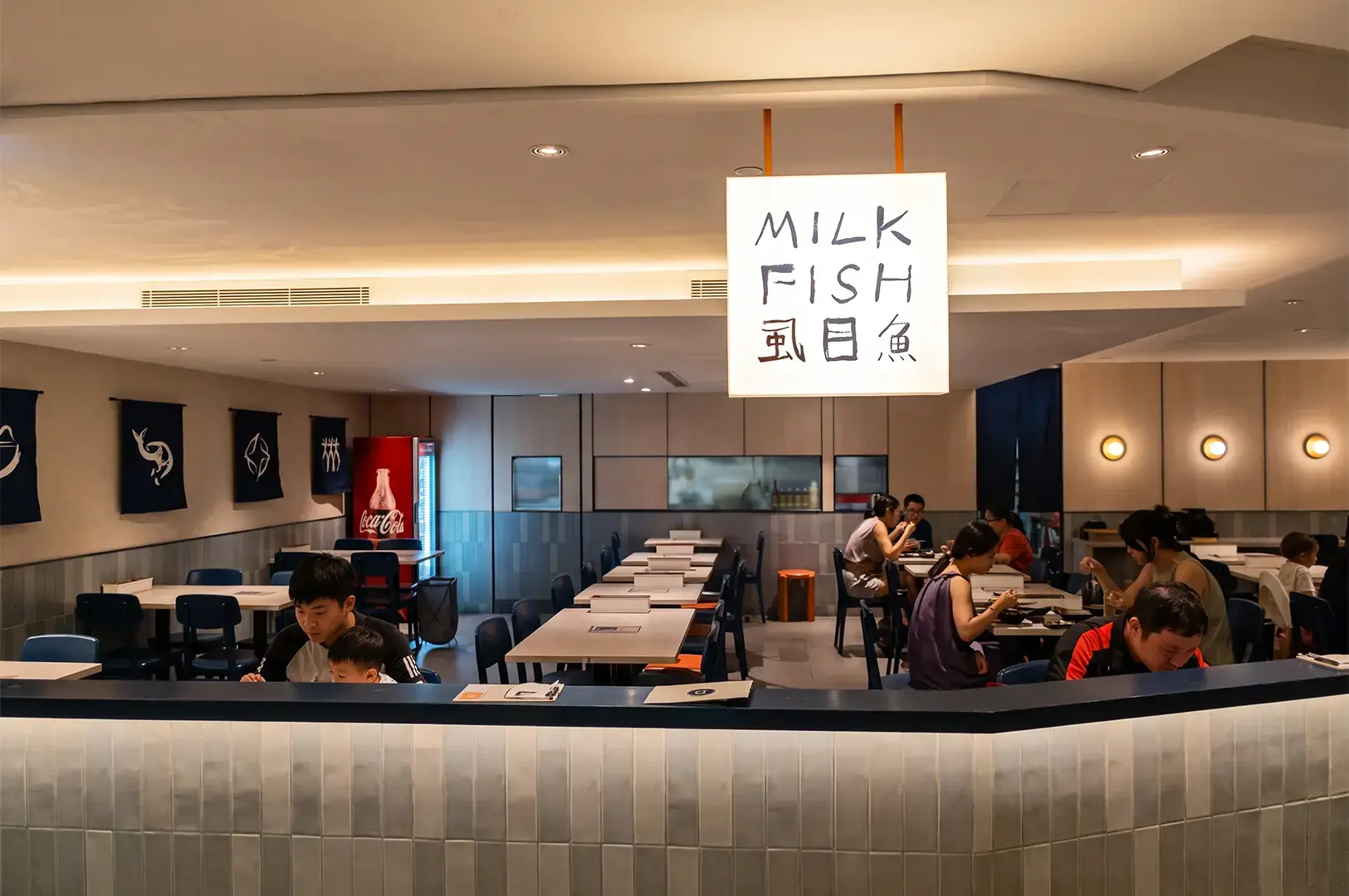 Wide angle shot of Milkfish & Broth with a simple white square logo signage and the store interior clearly visible behind.
