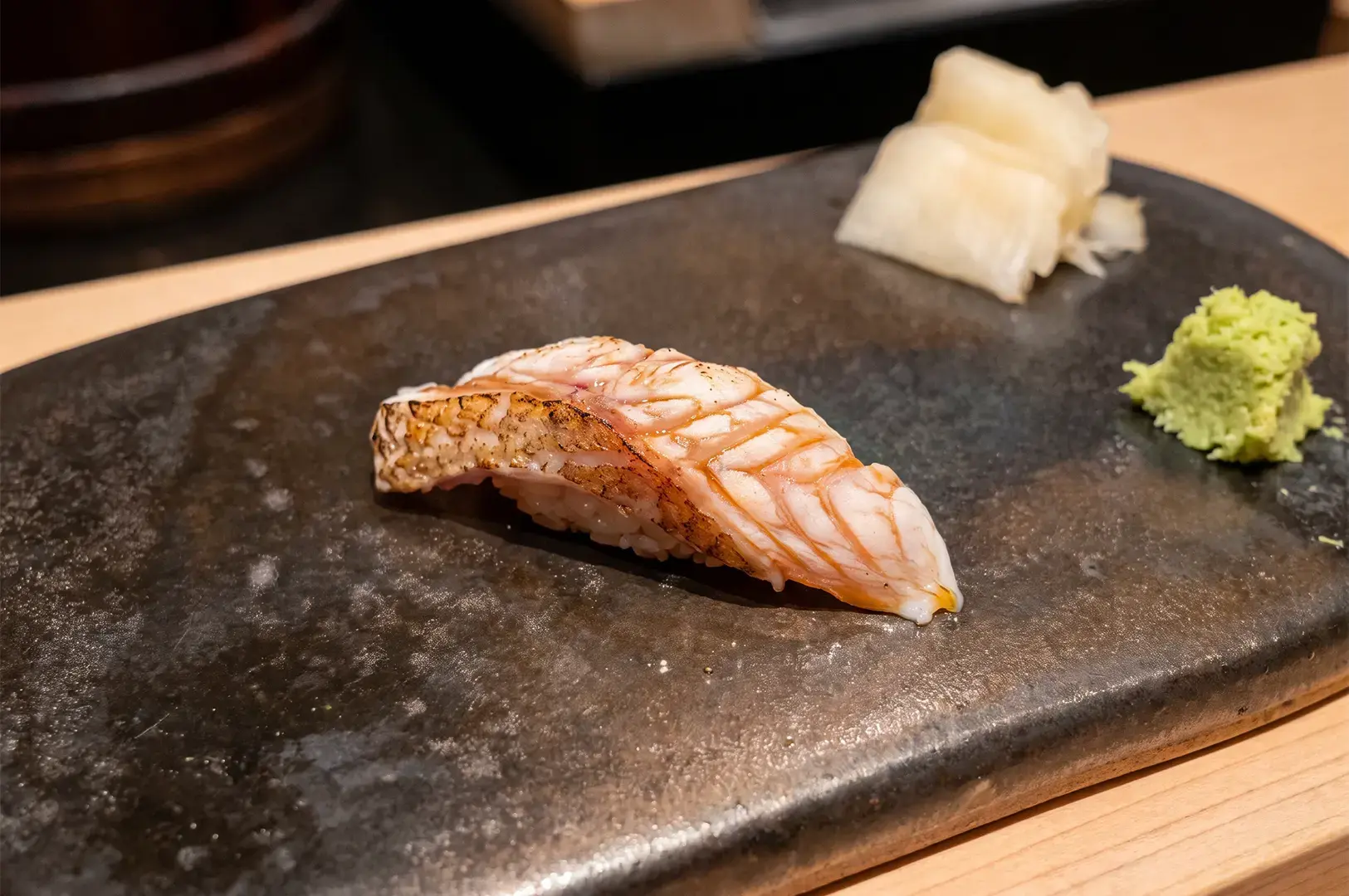 Young Sea Bream Sushi neatly arranged on with fresh ingredients served at Ginza Sushi Ichi.
