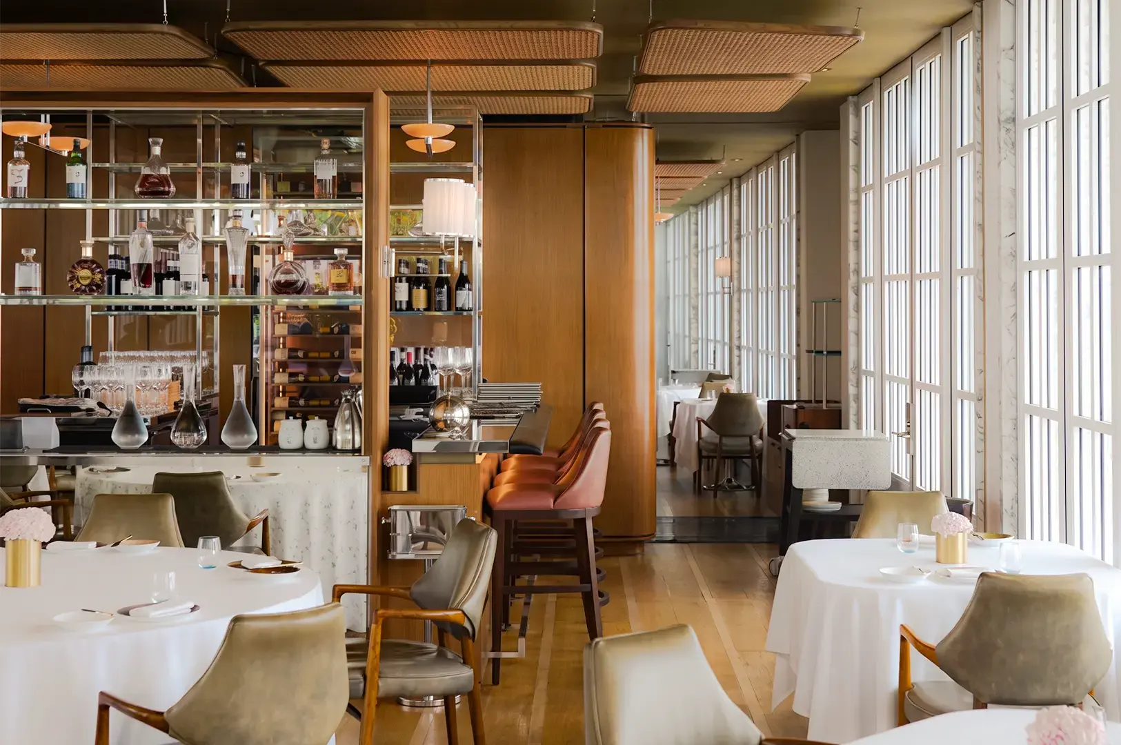 Spago Dining Room during the day, with a modern and sophisticated counter, tables, and chairs.